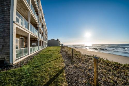 a building with a fence next to the beach at Oceanfront Contemporary in Lincoln City