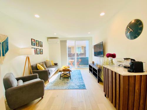 a living room with a couch and a clock on the wall at Modern Ballard Townhouse - 92 Walkscore & Rooftop! in Seattle