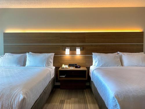 a hotel room with two beds and a nightstand between them at Holiday Inn Express & Suites Lexington Downtown Area-Keeneland by IHG in Lexington