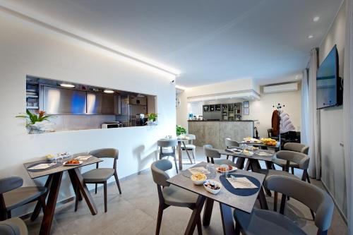 a dining room with tables and chairs and a kitchen at Albergo Giuan Arma di Taggia in Arma di Taggia