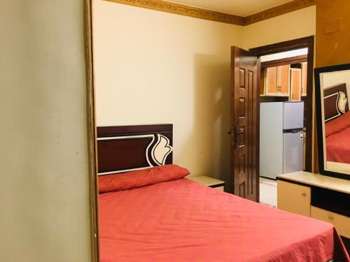 Schlafzimmer mit einem roten Bett und einem Spiegel in der Unterkunft Maadi Ring Road Sweet Apartment in Kairo