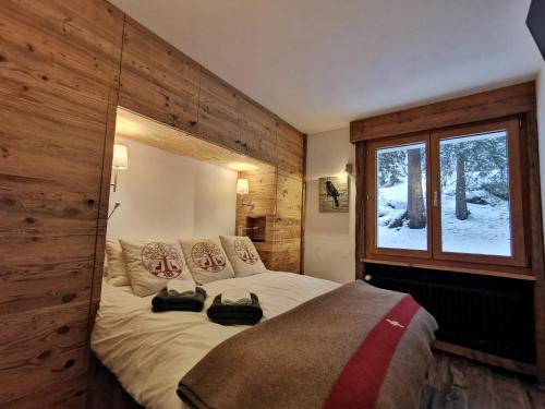 um quarto com uma cama grande e uma janela em Verbier Medran em Verbier