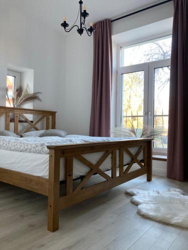 1 dormitorio con cama de madera y ventana grande en the house, en Poprad