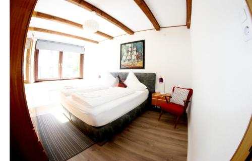 ゼーフェルト・イン・チロルにあるFamily Friendly Chalet - Central with Beautiful Mountain Viewsのベッドルーム1室(大型ベッド1台、赤い椅子付)