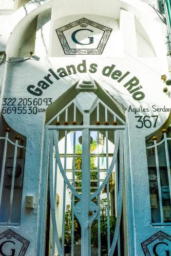 a door to a store with a sign on it at Garlands Del Rio Riverside Boutique Hotel in Puerto Vallarta