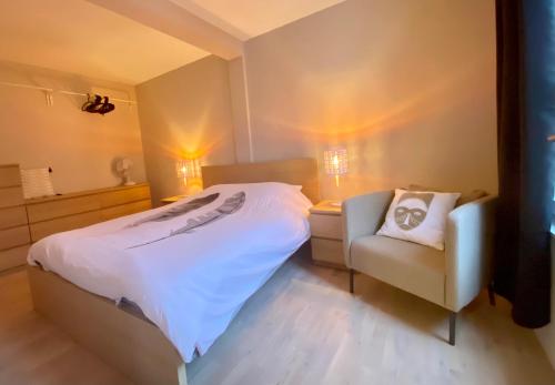 una camera con letto, sedia e vasca di Arche de Noé a Colmar