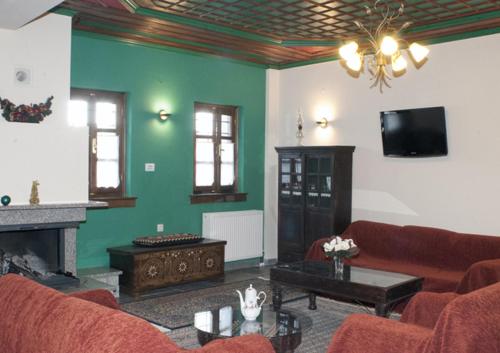 a living room with a couch and a fireplace at Hotel Dryades in Negádes