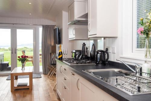 a kitchen with a sink and a counter top at Super King Lodge-Sleeps 2-HotTub-Sea View in Langbank