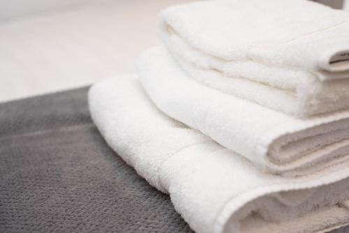 a stack of white towels sitting on a table at Luxurious Super-king Lodge with hot tub in Langbank