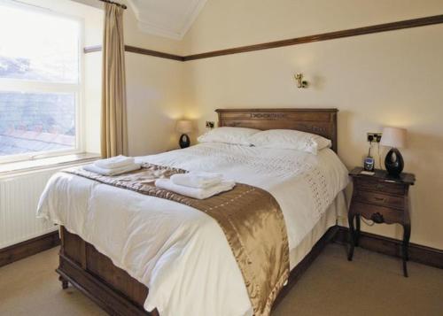 a bedroom with a large bed with two towels on it at Lovely Large home 10 Minute Walk to Barmouth Beach in Barmouth