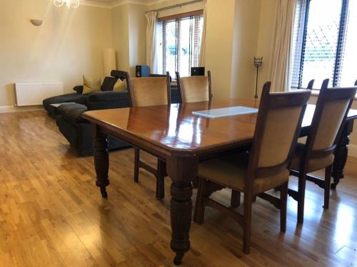 a dining room with a wooden table and chairs at Discreet luxury Super house! in Gleann Maghair
