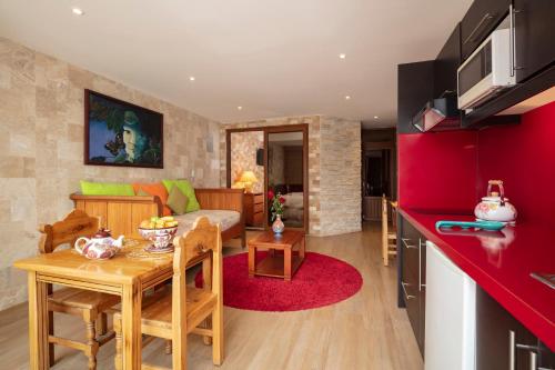 a kitchen and living room with a table and a couch at Casa del Balcon in Baños