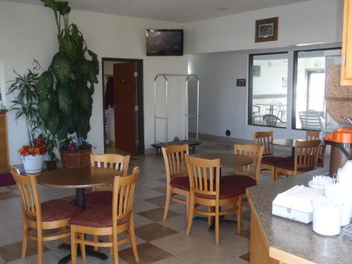 a dining room with tables and chairs and a tv at Super 8 by Wyndham Pendleton in Pendleton