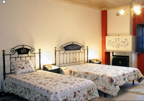 a bedroom with two beds and a fireplace at Hotel Dryades in Negádes