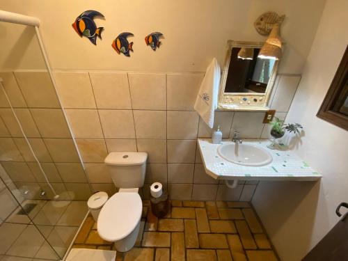 La salle de bains est pourvue de toilettes et d'un lavabo. dans l'établissement Pousada Villa São Pedro, à Garopaba