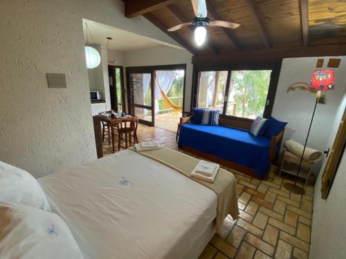 - une chambre avec un lit et un canapé dans l'établissement Pousada Villa São Pedro, à Garopaba