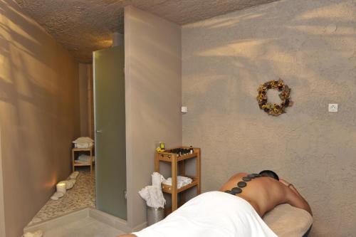 a person laying on a bed in a room at Ammos Naxos Exclusive Apartments & Studios in Naxos Chora