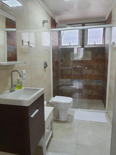 y baño con aseo, ducha y lavamanos. en Apartamento Beira Mar, en Balneário Camboriú