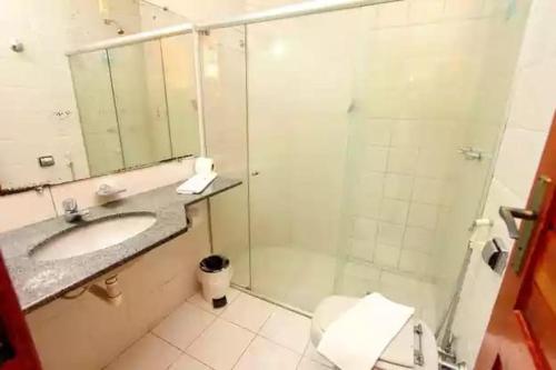 a bathroom with a shower and a sink and a toilet at BOULEVARD DA PRAIA Apart Hotel Beira mar in Porto Seguro