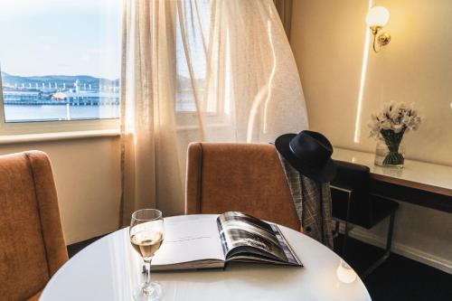 a table with a book and a glass of wine at Lenna Of Hobart in Hobart