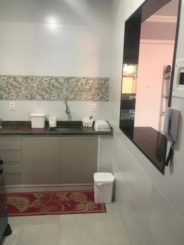 La salle de bains est pourvue d'un lavabo et de toilettes. dans l'établissement Apartamento com vista para o mar, à Arraial do Cabo