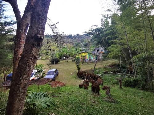 a view of a yard with a house in the background at Hotel Marrokos Aeropuerto José María Córdova in Rionegro