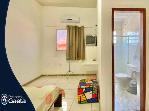 a room with a bathroom with a toilet and a shower at Pousada Gaeta Meaipe Guarapari in Guarapari