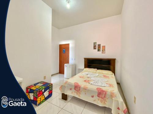 ein Schlafzimmer mit einem Bett in einem Zimmer in der Unterkunft Pousada Gaeta Meaipe Guarapari in Guarapari