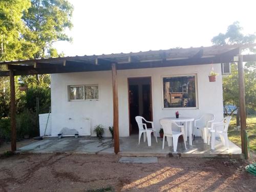 uma pequena casa branca com uma mesa e cadeiras em CandeYaz em Piriápolis