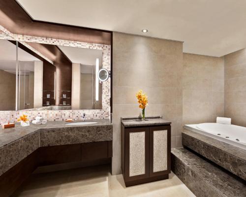 a bathroom with a tub and a large mirror at Shangri-La Tanjung Aru, Kota Kinabalu in Kota Kinabalu