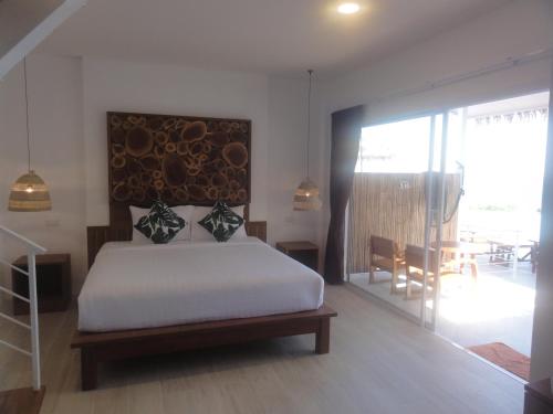 a bedroom with a white bed and a dining room at High Life Bungalow in Haad Yao