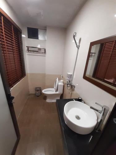 a bathroom with a white sink and a toilet at Homestay 715 View Sapa in Sapa