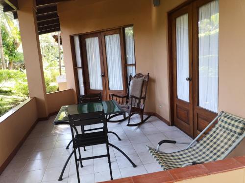 a screened in porch with a glass table and chairs at Condominio Villa Hermosa in Playa Hermosa
