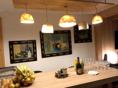 - une table avec un bol de fruits et des lampes pendant dans l'établissement Appartement moderne à Le Grand-Bornand 70 m² avec vue montagne, au Grand-Bornand