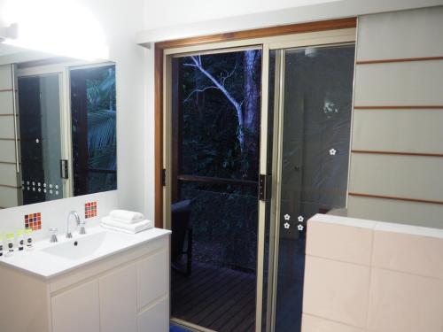 a bathroom with a shower and a sink at Cassawong Cottages in Mission Beach