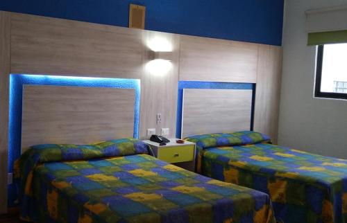 a hotel room with two beds in a room at Hotel Gilbert in Mexico City