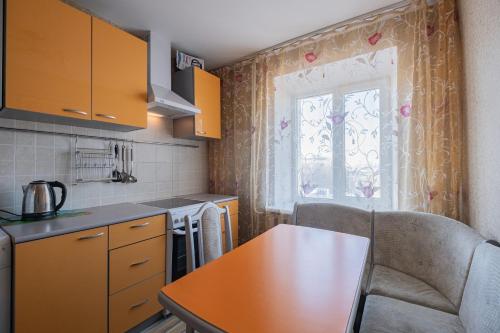 トムスクにあるАпартаменты Красноармейская 135の黄色のキャビネットとテーブル、窓付きのキッチン