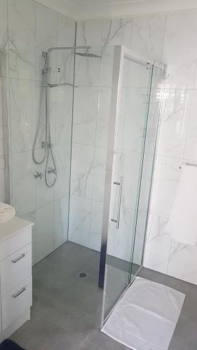 a shower with a glass door in a bathroom at Alkion Villa in Wagga Wagga
