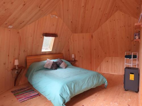1 dormitorio con 1 cama en una cabaña de madera en Lemunantu Domo Solar, en La Ensenada
