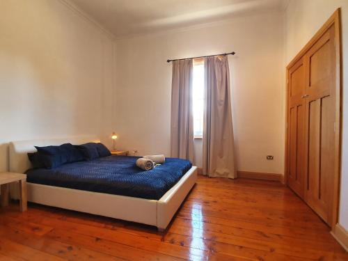 a bedroom with a blue bed and a window at Bellview Holiday House in Wentworth