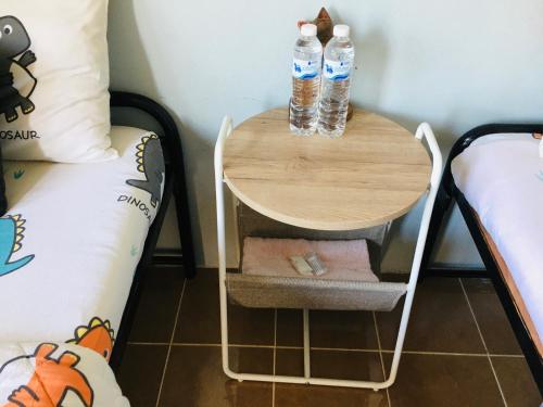 two bottles of water sitting on a table next to a bed at Saming Chiang Dao Guest House in Chiang Dao