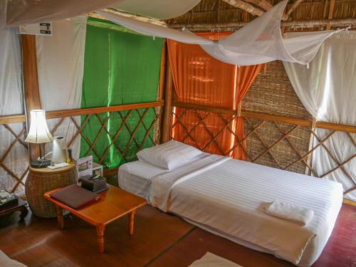 vKirirom Pine Resort في Chambok: غرفة نوم بسرير وطاولة في غرفة