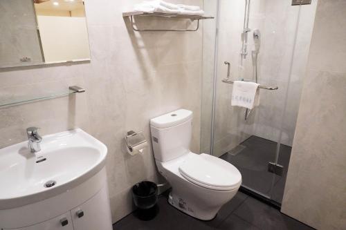 uma casa de banho com um WC, um lavatório e um chuveiro em Kao Yuan Hotel - Zhong Zheng em Taichung