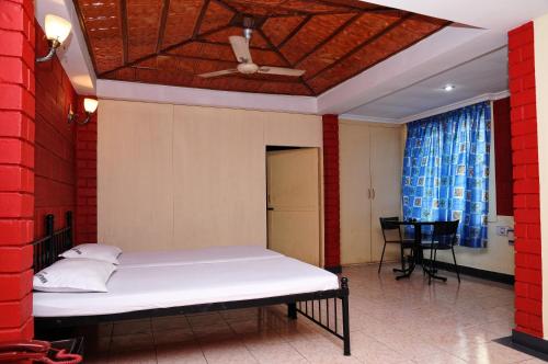 uma cama num quarto com uma parede vermelha em HOTEL HIGHLAND RESIDENCY em Mangalore