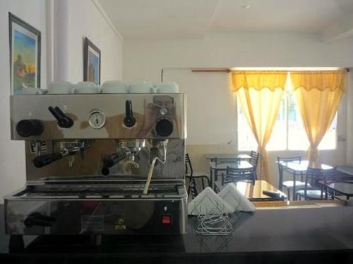a kitchen with a coffee maker and a table at Hotel Ruma in Salta