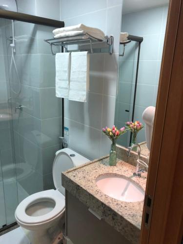 a bathroom with a toilet and a sink at Magnífico Flat no melhor de Manaíra - Apart Hotel in João Pessoa