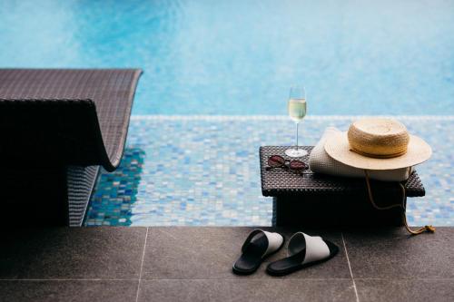 a hat and a pair of shoes and a glass of wine at The Clan Hotel Singapore by Far East Hospitality in Singapore