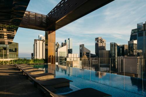 a pool on the roof of a building with a city skyline at The Clan Hotel Singapore by Far East Hospitality in Singapore