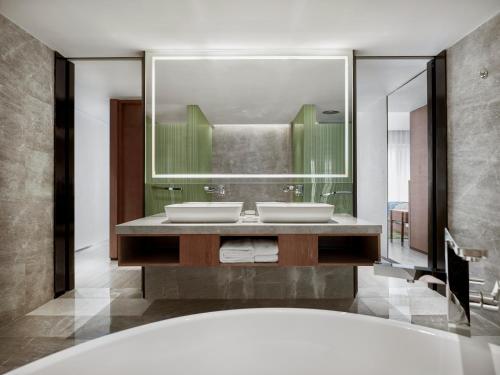 a bathroom with two sinks and a large mirror at Holiday Inn Resort Sanya Bay by IHG in Sanya
