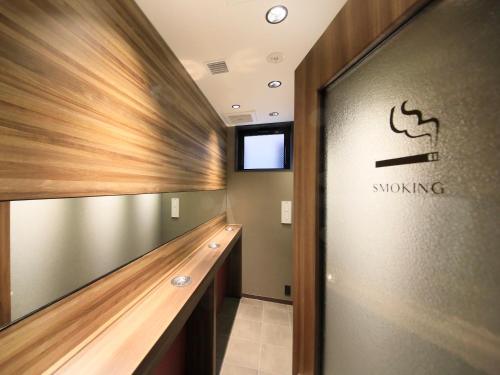 a hallway with a snong sign on the wall at The Hedistar Hotel Kyoto Nijo Comic & Books in Kyoto